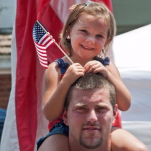 Dad and daughter with American flag at Freedom Fest | Watershed Cabins Bryson City Rentals