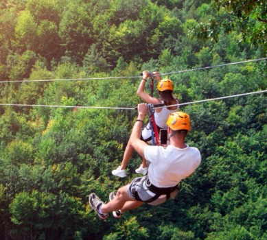 Dad ziplining across treetops | Watershed Cabins Bryson City Cabin Rentals