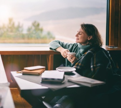 Woman sipping coffee and enjoying lake views | Watershed Cabins NC Smoky Mountain Rentals